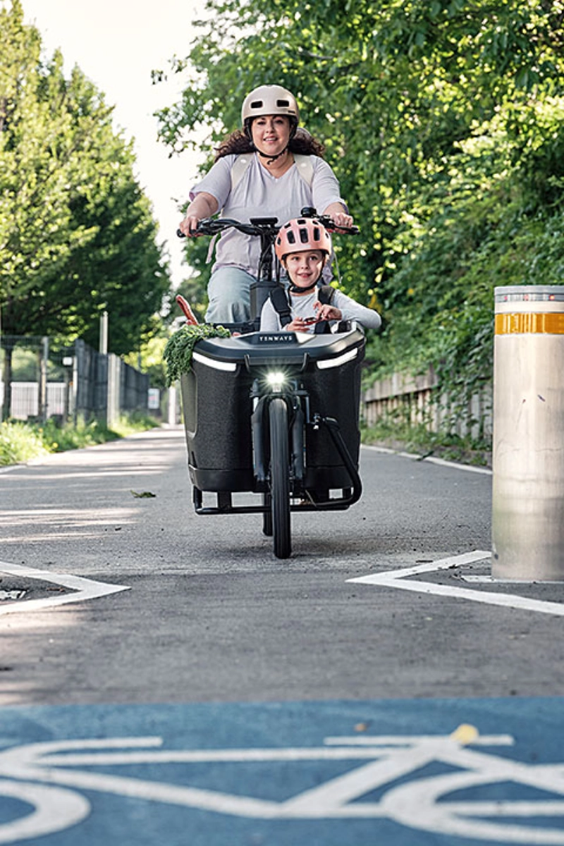 Mama mit Kind im Lastenrad